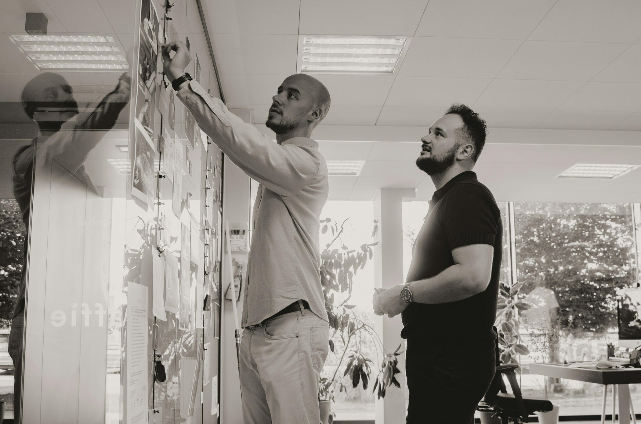 Dos socios revisando estrategias sobre un pizarrón